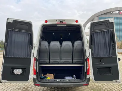 Mercedes Sprinter minibüsün arka kapıları açık bagaj bölümü